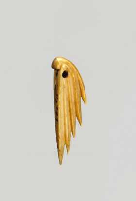 An ornament made of bone carved in the form of a fin of a fish.