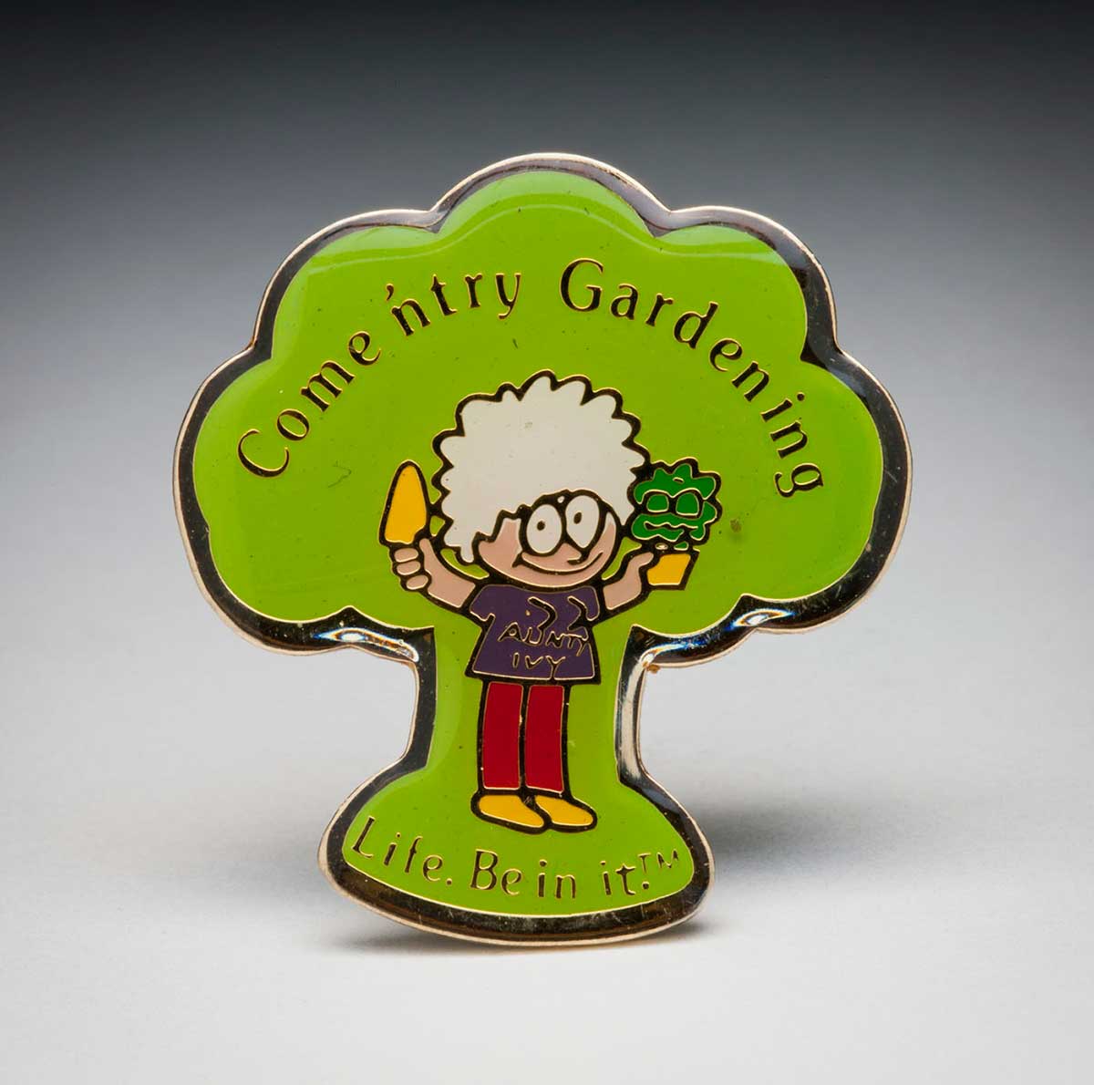 A small badge in the shape of a tree with green background. A caricature of a woman holds a trowel and plan. Text reads: Come and try gardening. - click to view larger image