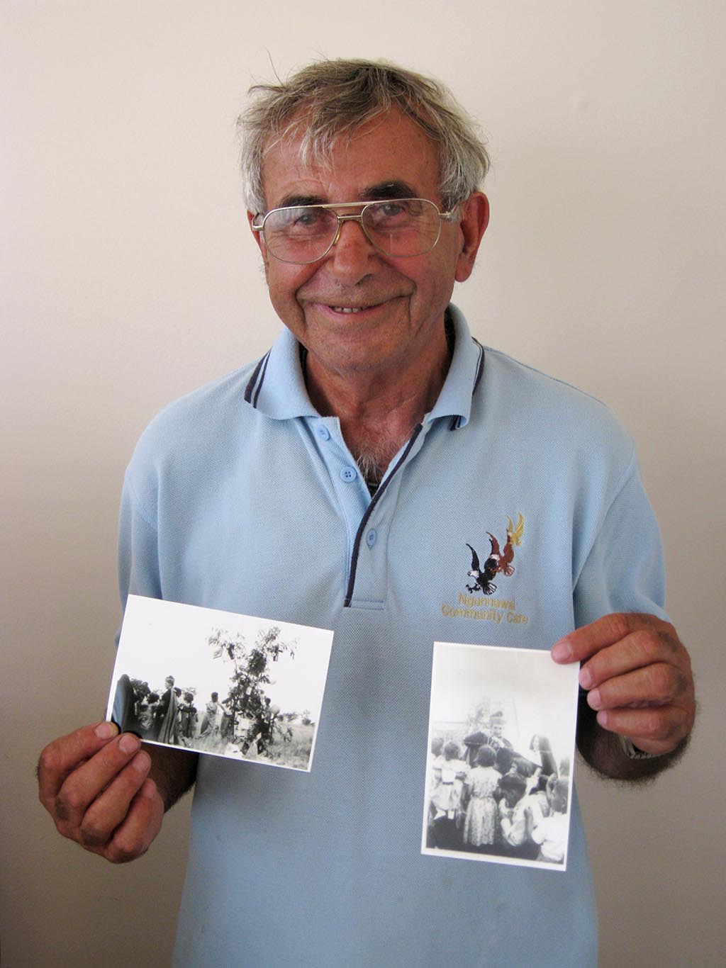 Eric Bell holding two black and white photographs. - click to view larger image