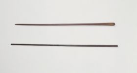 Clubs made of brown, heavy wood, one of nearly black wood.