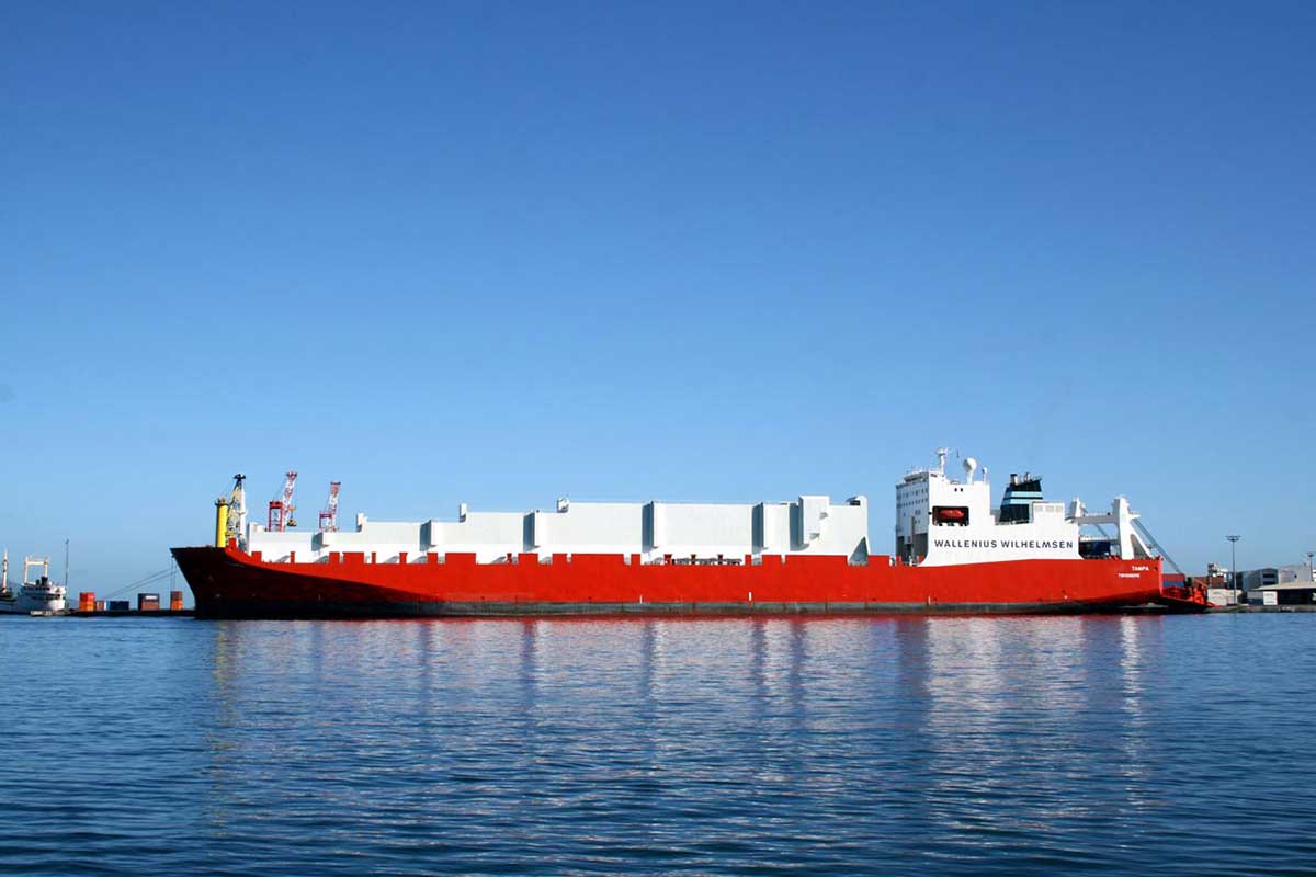Red and white container vessel moored.