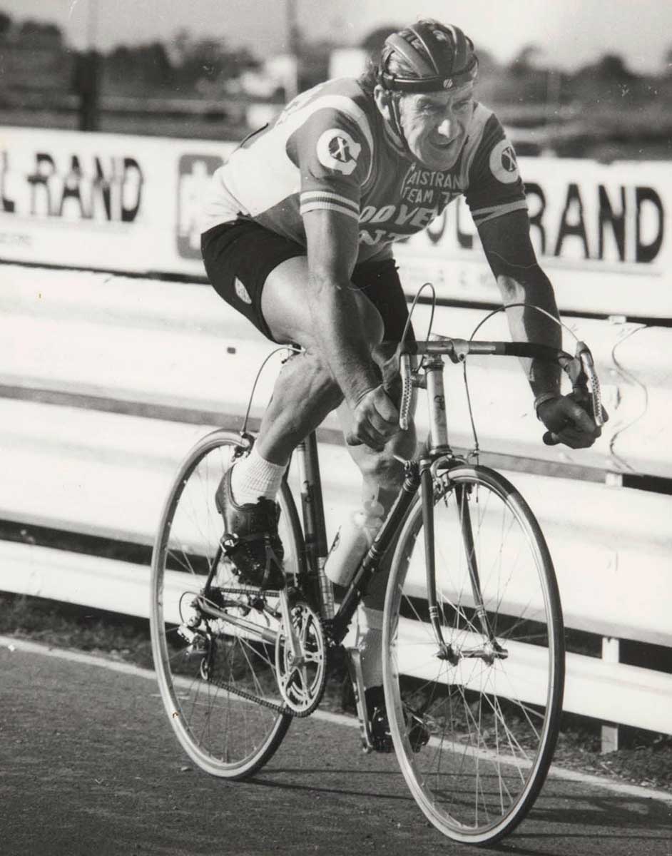 A black and white photo of Jim Coyle on his bicycle. - click to view larger image