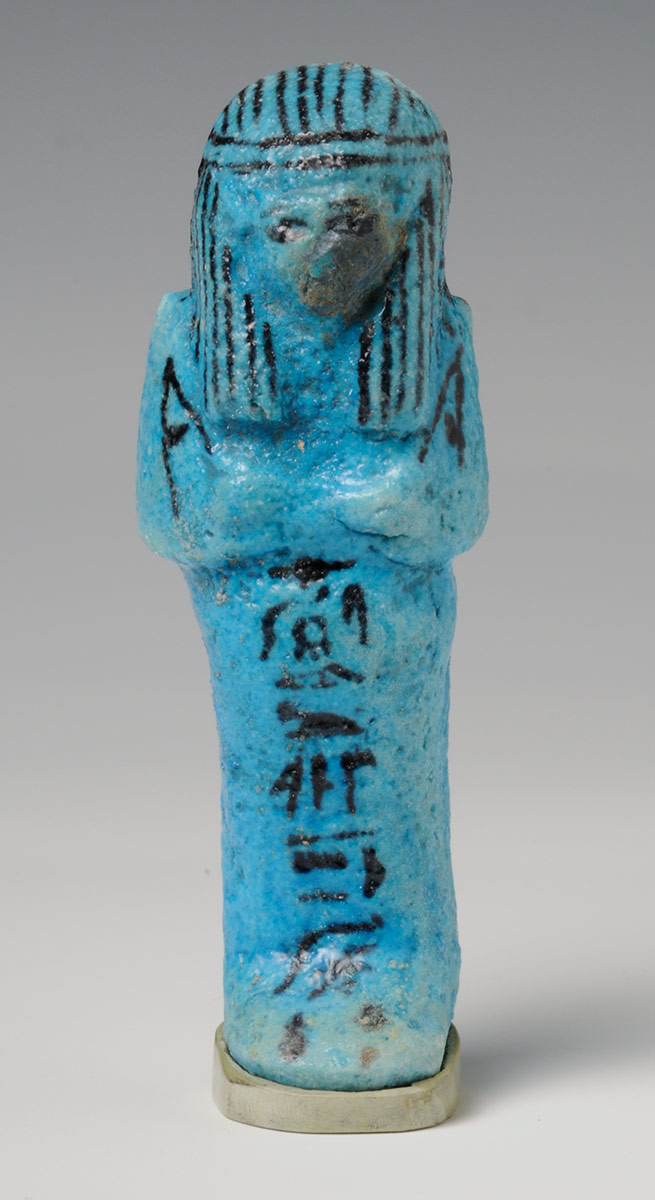 Bright blue Egyptian funerary figure with arms crossed at the front and details including hieroglyphics in black on the front.  - click to view larger image