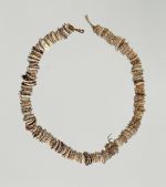 Necklace made from small worn olive nut shells strung together on a cord made of a plant material.