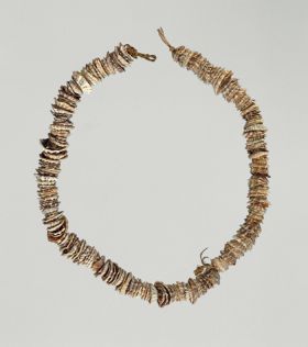 Necklace made from small worn olive nut shells strung together on a cord made of a plant material.