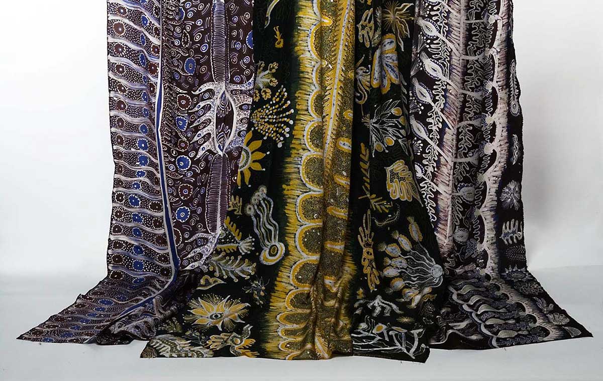 Silk batik fabric with Ernabella motifs in yellow, black, blue and white.