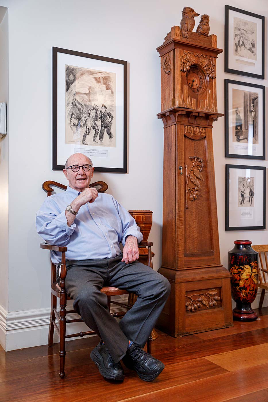 Trevor Kennedy sitting on a chair next to a longcase clock. - click to view larger image