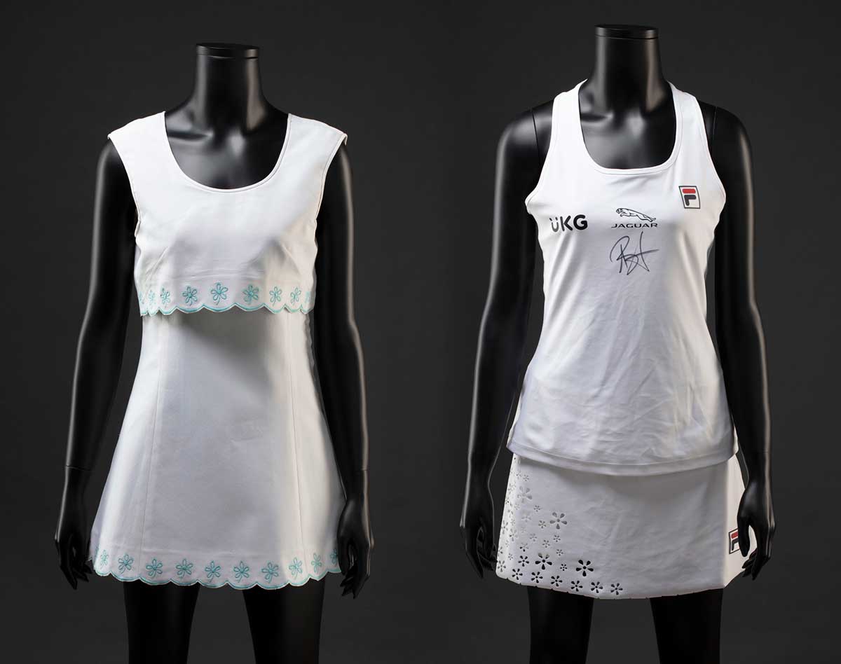 Left, a white sleeveless tennis dress with a scalloped hem and bolero-style bodice both featuring an embroidered aqua flower trim at the hem and bustline. Right, a white Fila 'Trailblazer' tennis outfit consisting of a tank top and skort. The racerback tank top has a laser cut floral decoration at the back. The front features a 'UKG' logo and 'JAGUAR' logo, as well as a handwritten signature in black ink.