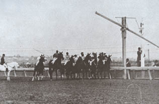 The starter of the 1898 Victoria Racing Club Derby at Flemington raises the rope barrier to start the race.